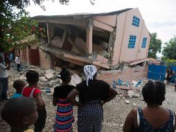 Habitantes miran una escuela dañada por el temblor en Gros Morne. AP/D. Nalio Chery