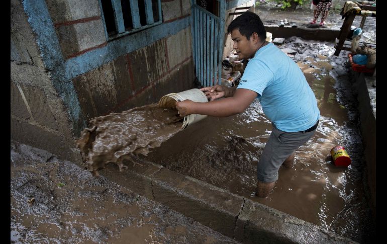 Un hombre saca agua de su casa inundada. EFE / J. Torres