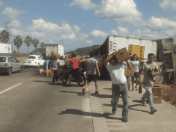 Niños, mujeres y hombres acudieron a la zona del accidente para robar cartones de cerveza. ESPECIAL