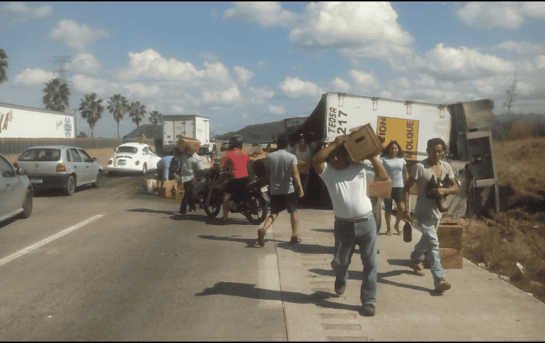 Niños, mujeres y hombres acudieron a la zona del accidente para robar cartones de cerveza. ESPECIAL