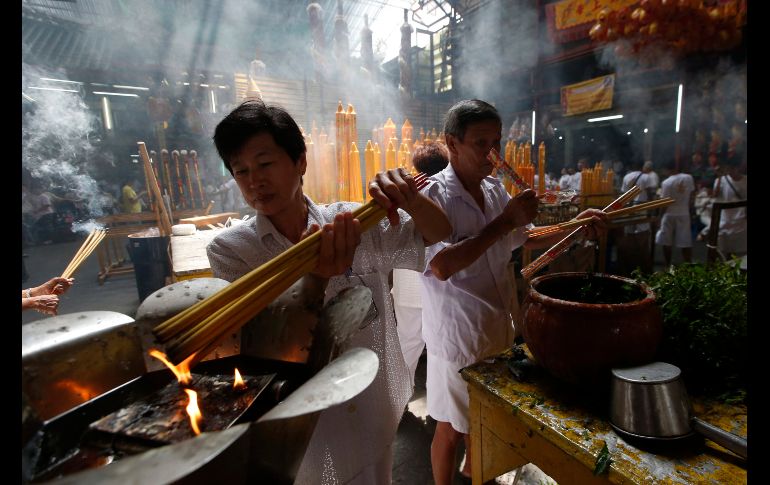 Una mujer enciende incienso en un templo chino en Bangkok, Tailandia, por la celebración del festival vegetariano. Los fieles se abstienen de comer alimentos animales durante los nueve días del festival. AP/S. Lalit