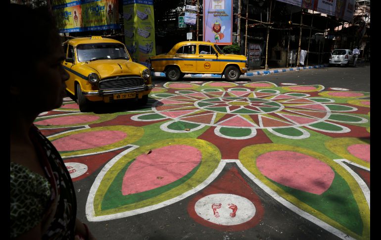 La intersección de una calle en Calcuta, India, se pintó con colores previo al festival hindú de 