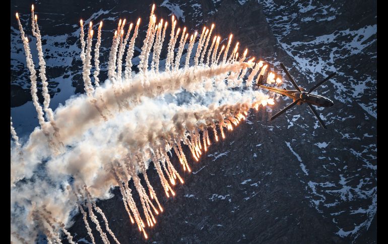 Un helicóptero Super Puma Cougar lanza luces de emergencia en Brienz, Suiza, durante un evento anual de la Fuerza Aérea Suiza sobre los Alpes. AFP/F. Coffrini