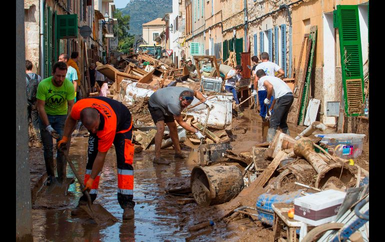 Labores de limpieza se realizan en una calle en Sant Llorenc des Cardassar, en la isla española de Mallorca, luego de inundaciones por lluvias torrenciales que han dejado 12 muertos. AFP/J. Reina