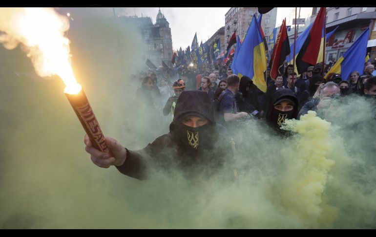 Activistas y simpatizantes de los partidos nacionalistas ucranianos queman bengalas, antorchas y granadas de humo durante su marcha para conmemorar el 76 aniversario de la creación del Ejército Insurgente de Ucrania, en el centro de Kiev. EFE/EPA/S. Dolzhenko