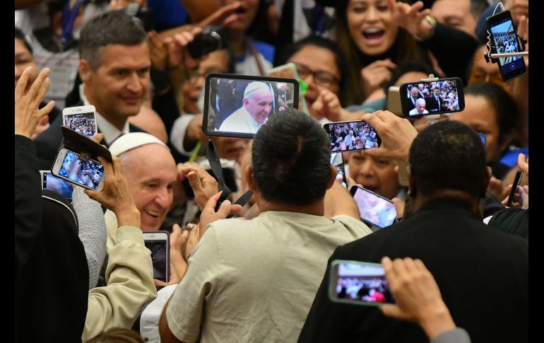 Fieles católicos toman fotos del Papa Francisco a su llegada a una audiencia con peregrinos salvadoreños en el Vaticano. AFP/A. Pizzoli
