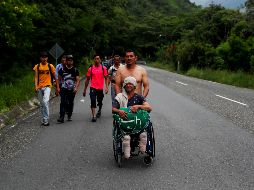 Nery Maldonado, empujado por su amigo Omar Orellana, migra junto con la caravana de hondureños que espera llegar a Estados Unidos y que ahora continúa su camino por Esquipulas. EFE/E. Biba