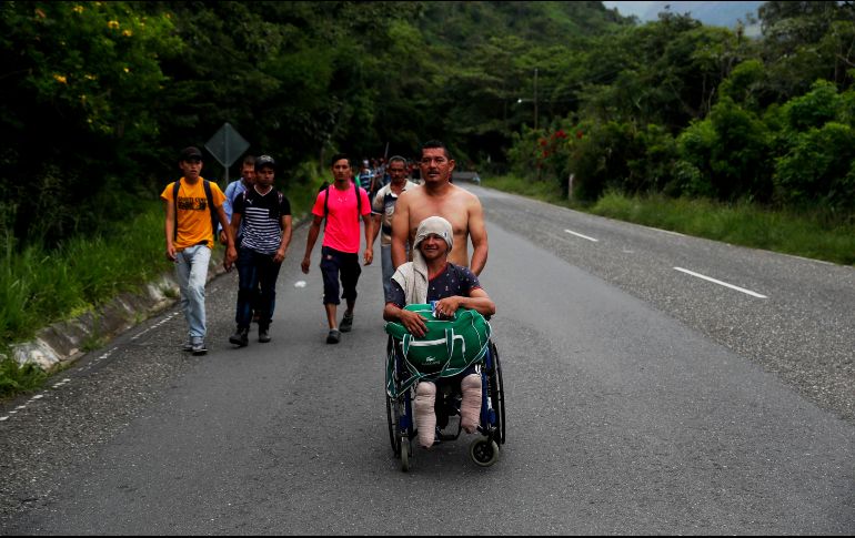 Nery Maldonado, empujado por su amigo Omar Orellana, migra junto con la caravana de hondureños que espera llegar a Estados Unidos y que ahora continúa su camino por Esquipulas. EFE/E. Biba