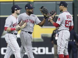 Los jugadores Andrew Benintendi (i), Jackie Bradley Jr. (c) y Mookie Betts (d) de los Medias Rojas de Boston celebran su triunfo tras vencer a los Astros de Houston. EFE/M. Wyke