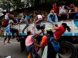 Migrantes hondureños que van en grupo hacia la frontera de México suben a camiones para ir a la Ciudad de Guatemala. Se trata de más de dos mil personas que quieren llegar a EU. EFE/E. Biba