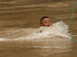 Un niño, que hace parte de un grupo de migrantes hondureños, cruza el río Goascorán rumbo a la frontera mexicana con la esperanza de llegar a los Estados Unidos. EFE / R. Sura