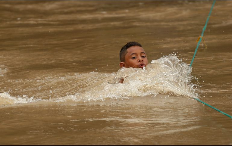 Un niño, que hace parte de un grupo de migrantes hondureños, cruza el río Goascorán rumbo a la frontera mexicana con la esperanza de llegar a los Estados Unidos. EFE / R. Sura