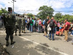 Migrantes hondureños hacen fila frente a un reten policial en la frontera de Agua Caliente, entre Honduras y Guatemala. EFE/G. Amador
