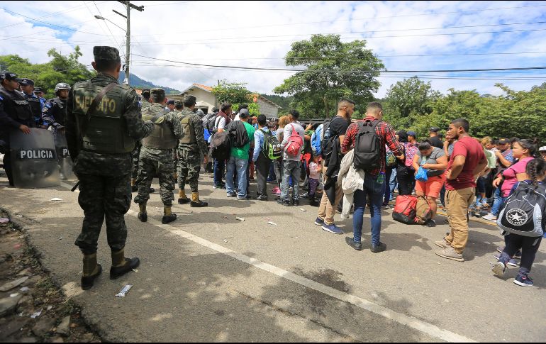 Migrantes hondureños hacen fila frente a un reten policial en la frontera de Agua Caliente, entre Honduras y Guatemala. EFE/G. Amador