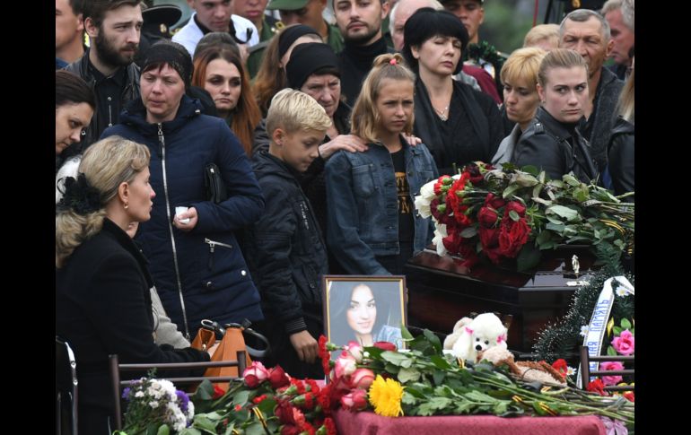 Dos días después de la matanza que dejó 20 muertos en una escuela de Kerch, en Crimea, habitantes acuden a un último homenaje a las víctimas. AP