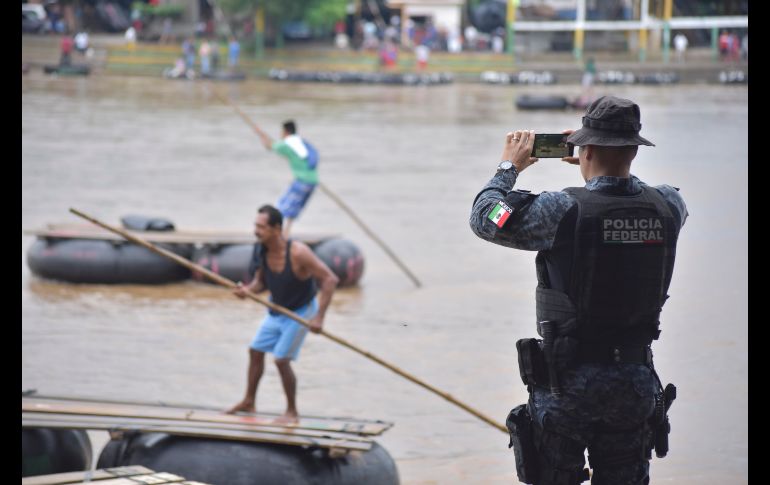 Un policía federal registra los movimientos de los migrantes en el margen del Río Suchiate, que divide Ciudad Hidalgo y Tecún Umán.