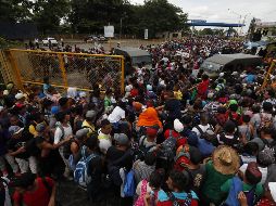 La caravana, que se dirige hacia Estados Unidos, cruza a la fuerza el primer cerco policial de unos cien antimotines para dirigirse a la reja que separa a Guatemala de México. EFE / E. Biba