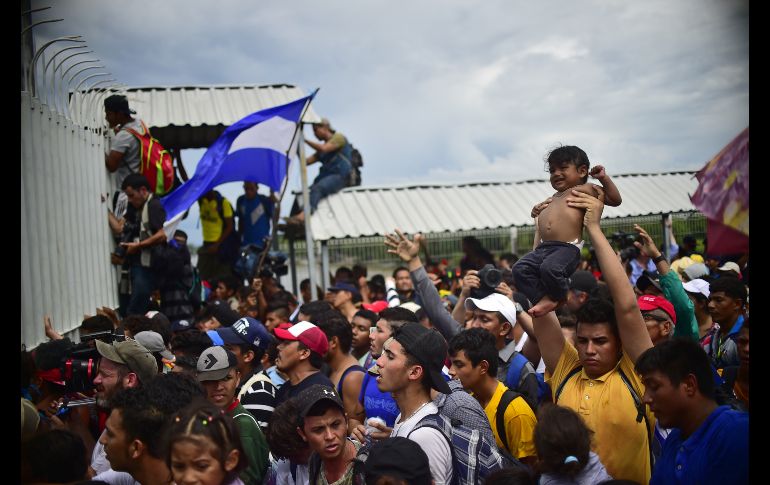 La multitud se topa con la reja en la entrada a México. AFP/P. Pardo