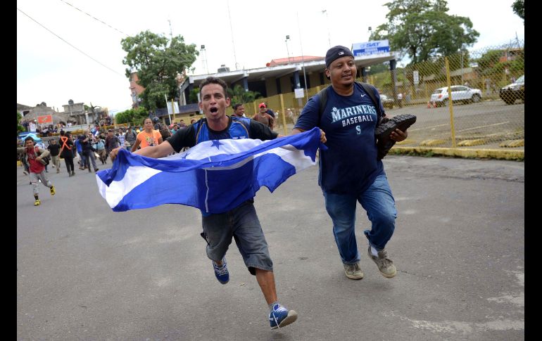 Migrantes corren por el cruce fronterizo. Tras el cerco en territorio guatemalteco, hay que atravesar un puente.