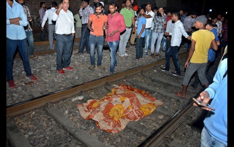 El cuerpo de una víctima de un accidente de tren yace cubierto en una vía en Amritsar, India.  Al menos 58 personas murieron al ser atropelladas por el tren, cuando cientos de devotos que celebraban una festividad cerca de un paso a nivel no se percataron de su llegada. AP/P. Gill