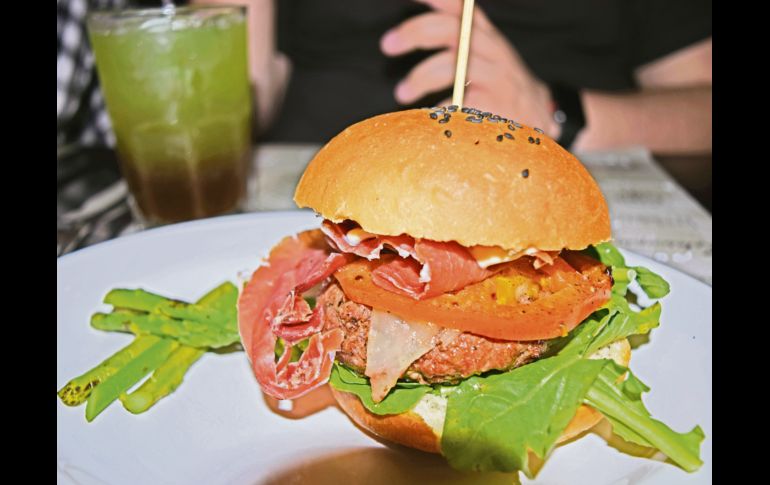 Hamburguesa Ibérica. Preparada con carne de ribeye a la parrilla, montada sobre pan artesanal -hecho en Gaspar- arúgula, jitomate sellado y perfumado con orégano y aceite de olivo, jamón serrano y alioli.