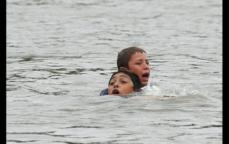 Dos niños a punto de ahogarse al intentar cruzar el Río Suchiate; un balsero los rescata. EFE