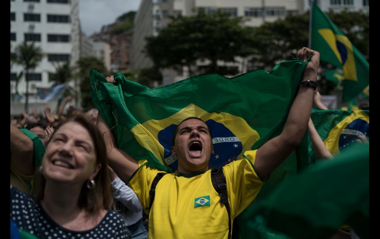 Brasileños escuchan el himno nacional durante un mitin para el candidato presidencial Jair Bolsonaro en Río de Janeiro. Brasil celebra la segunda vuelta de las elecciones presidenciales el próximo domingo. AP/L. Correa