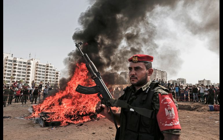Un integrante del movimiento Hamas palestino vigila mientras otros queman una pila de drogas confiscadas en la Ciudad de Gaza. AFP/M. Hams