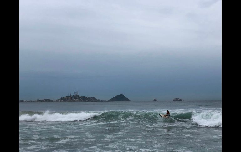 Un hombre surfea en Mazatlán, Sinaloa. Se espera que el meteoro descienda a categoría 3 o 2 antes de entrar a territorio mexicano, a unos 85 kilómetros al este-sureste de Mazatlán