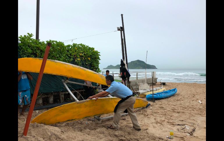 Un hombre recoge un kayak de una playa en Mazatlán, Sinaloa, previo a la llegada del huracán 