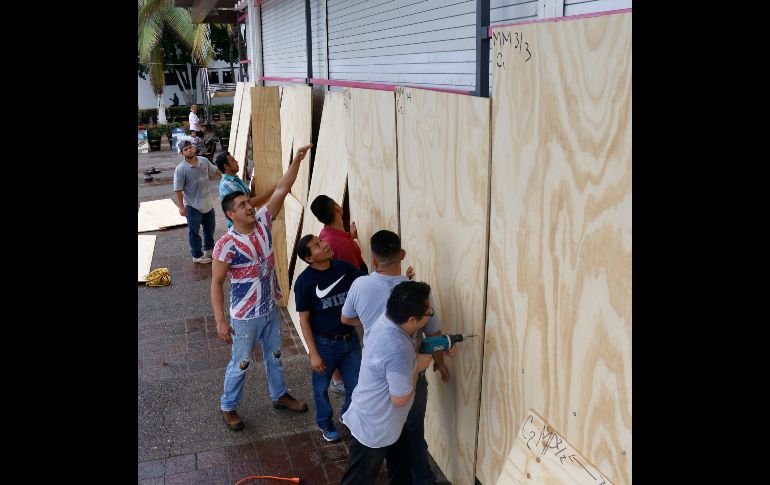 Habitantes protegen sus negocios en Puerto Vallarta, Jalisco. Autoridades estatales tomaron la decisión de evacuar de forma preventiva la zona hotelera de este puerto.