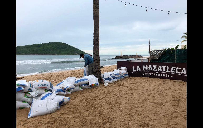 Colocación de costales de arena en un restaurant de Mazatlán.