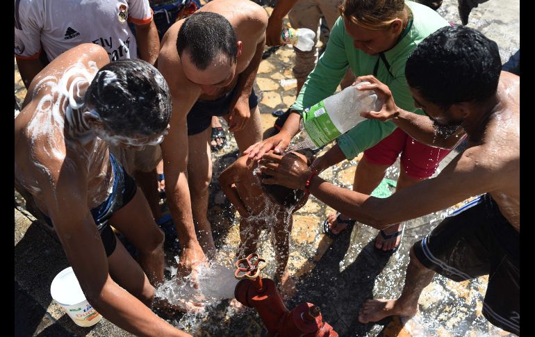 Un grupo se da un baño improvisado en Tapachula.
