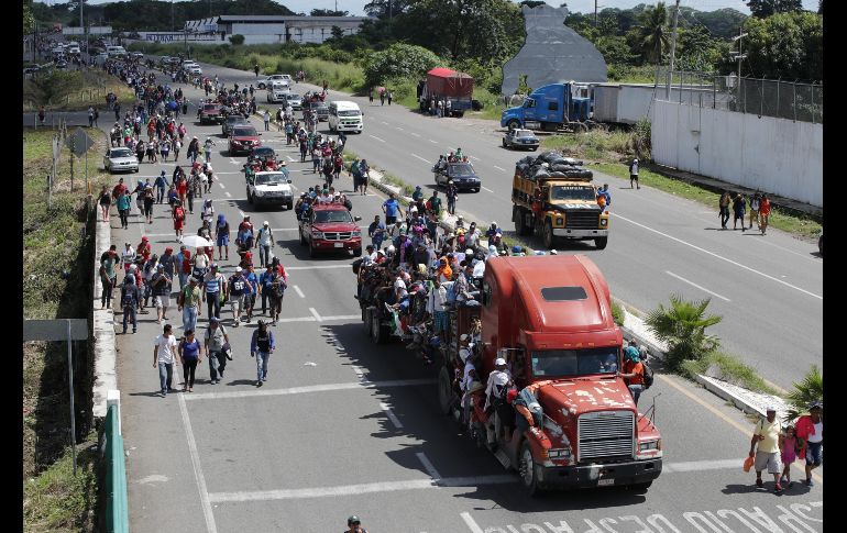 Migrantes centroamericanos suben a vehículos que se encuentran en el camino para continuar por territorio mexicano rumbo a su objetivo principal, Estados Unidos, tras haber pasado la noche en Tapachula, Chiapas.
