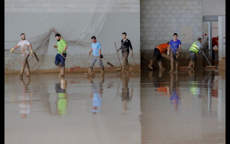 Voluntarios limpian de agua y barro zonas del Polideportivo de la localidad española de El Rubio, afectada este fin de semana por el temporal de lluvia. EFE/J. Muñoz