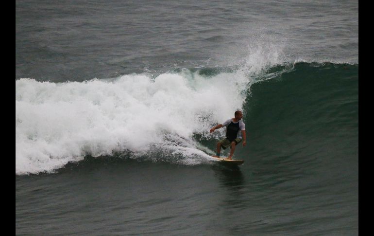 Un surfista aprovecha las altas olas esta mañana en Mazatlán.