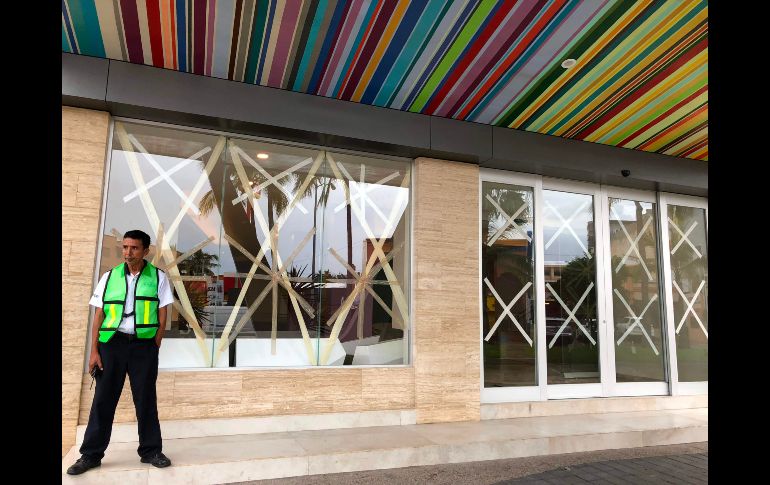 Las ventanas de un negocio tienen cinta para protegerlas de los efectos de 