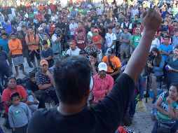 Migrantes hondureños se concentran durante un periodo de descanso en Huixtla, Chiapas, en su travesía hacia Estados Unidos. EFE/R. Pardo