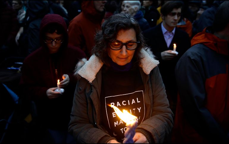 Una persona sostiene una vela durante un acto de homenaje a las víctimas. AP/M. Rourke