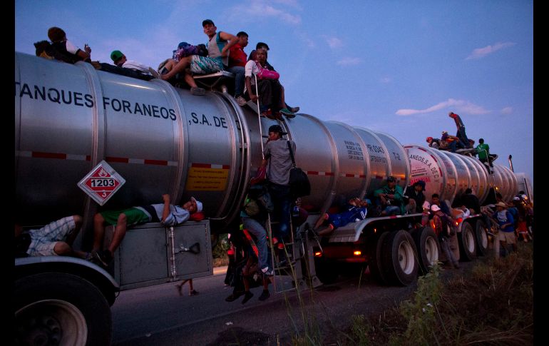 Personas que viajan en la Caravana de Migrantes se suben a una pipa que transporta material peligroso con la esperanza de que el conductor les permita viajar de 