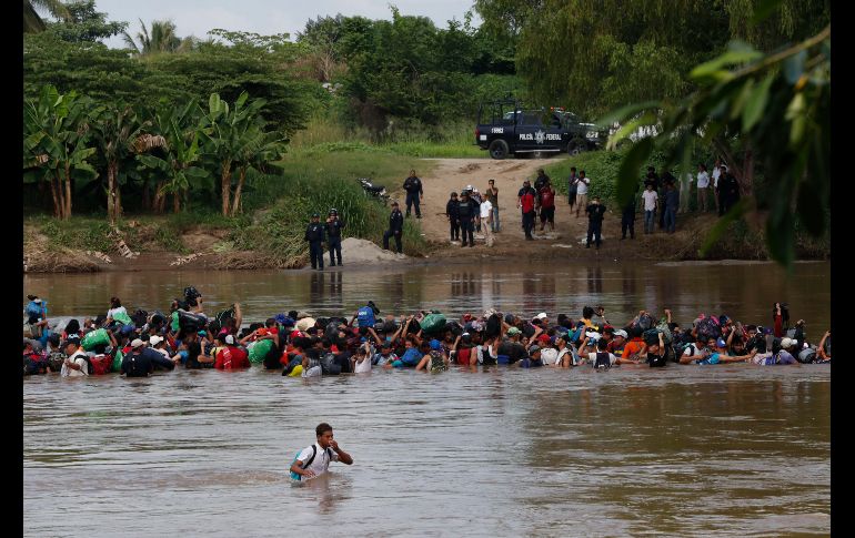 Integrantes de la segunda caravana de migrantes, en su mayoría hondureños, cruzan a pie el río Suchiate por una parte que no es muy profunda y que separa a Guatemala de México, en un nuevo intento por continuar su travesía hacia Estados Unidos. EFE / E. Biba