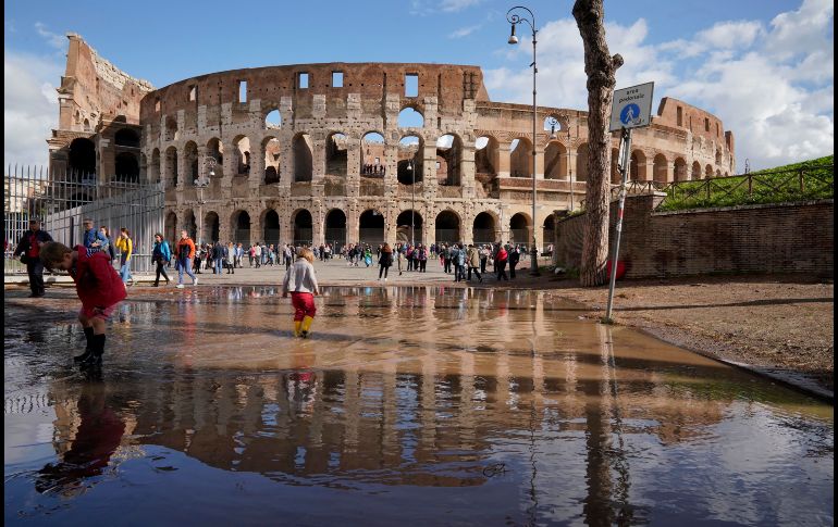Niños juegan en un charco junto al antiguo Coliseo romano, un día después de fuertes vientos y lluvias que azotaron a varias ciudades italianas y causaran severas afectaciones. AP / A. Medichini