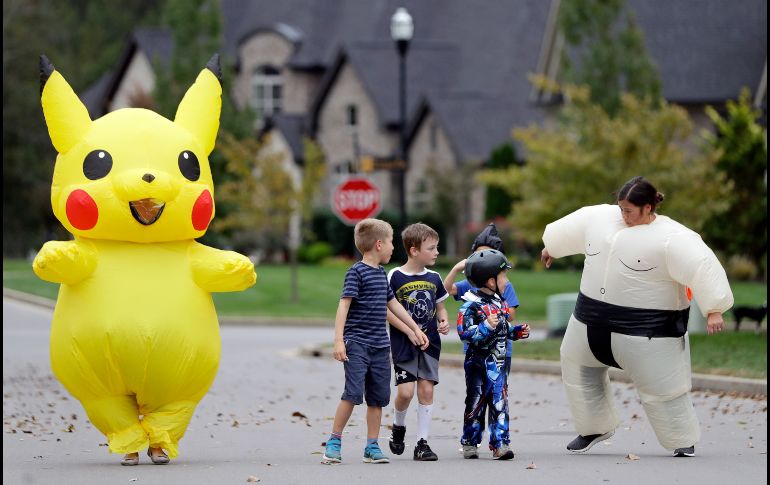 Una pareja de papás se disfrazaron de Pikachú y un luchador de sumo y así caminaron con sus hijos rumbo a la escuela el día de Halloween en Nashville. AP / M. Humphrey