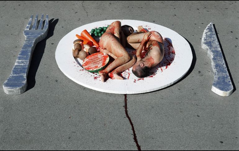 Dos activistas de la asociación AnimaNaturalis convirtieron sus cuerpos en pedazos de carne sobre un plato gigante como parte de una acción pública para llamar la atención sobre los beneficios de una dieta libre de carne con motivo del Día Mundial del Veganismo. EFE / A. Dalmau