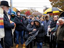 A pesar de la llovizna, el ex rabino Chuck Diamond dirige el servicio de 45 minutos que incluye oraciones, cánticos y poesía y el reverendo Lee Clark ofrece una breve plegaria. AP / G. Puskar