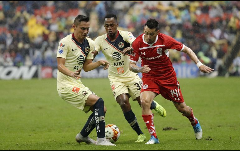 Los jugadores de América Paul Aguilar (i) y Alex Ibarra (c) disputan el balón con Rubens Sambueza (d) de Toluca. EFE/J. Méndez