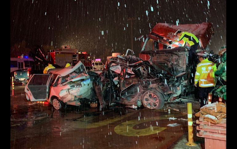 Oficiales y rescatistas trabajan en el sitio de un accidente ocurrido el sábado en Lanzhou, China. Al menos 15 personas murieron después de que un camión pesado perdiera el control y chocara contra una treintena de vehículos que esperaban en una caseta de pago en una autopista. AFP