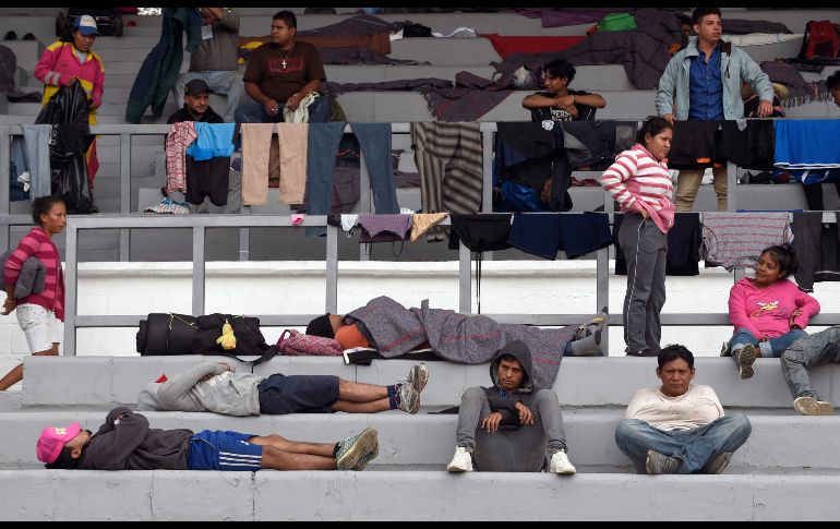 Migrantes se acomodan en las gradas del estadio Jesús 