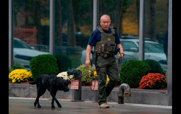 Un miembro del Cuerpo de Alguaciles de Estados Unidos  (US Marshal) camina con un agente canino en las inmediaciones del lugar donde se realiza el juicio contra 