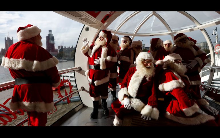 Integrantes de la Escuela de Santa Claus observan desde el London Eye en Londres, Inglaterra. Los Santa trabajarán en tiendas y centros comerciales para esta temporada navideña. AP/A. Grant
